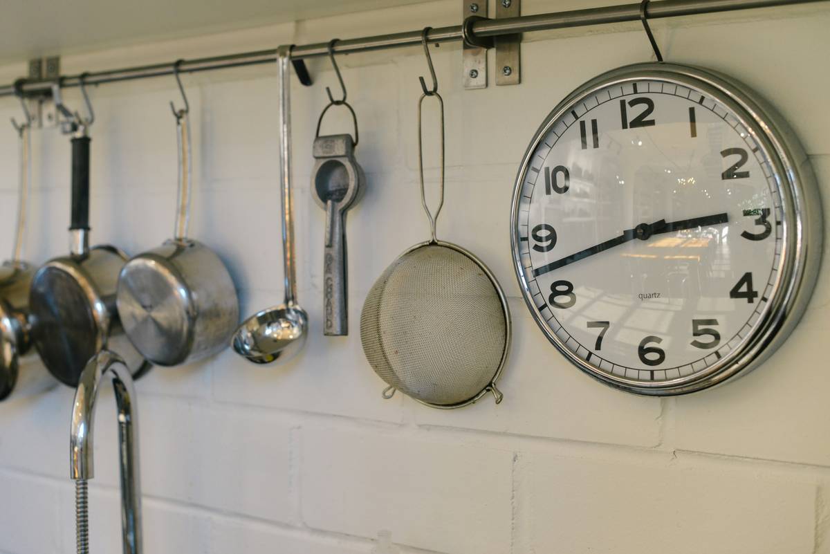 Digital barometer beside a stainless steel pressure cooker, displaying real-time PSI and altitude — pressure cooking technique tool measuring atmospheric